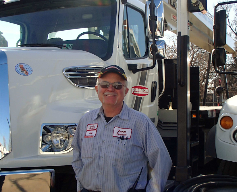 Guy Tanney standing in front of a Runnion Equipment truck