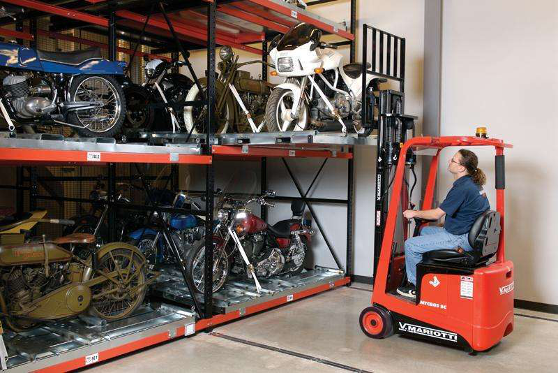 Mariotti forklift lowering a white motorcycle from a shelving unit