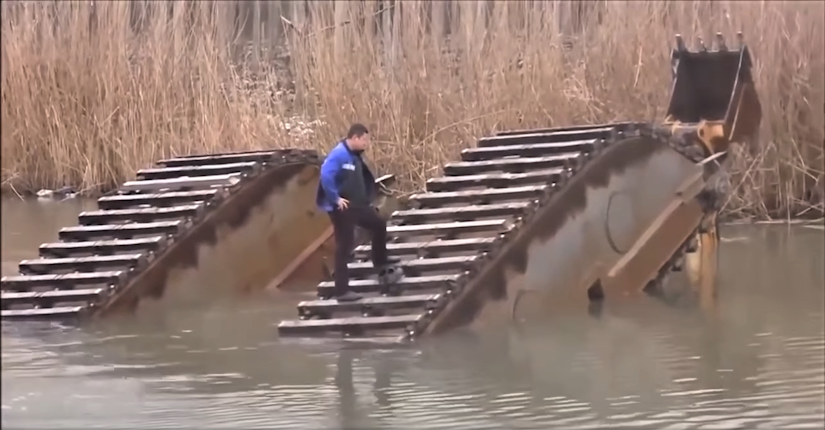 Man standing on amphibious excavator