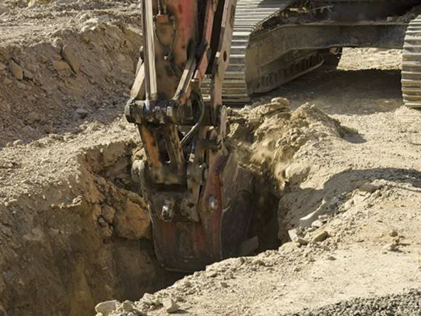 excavator digging trench at jobsite