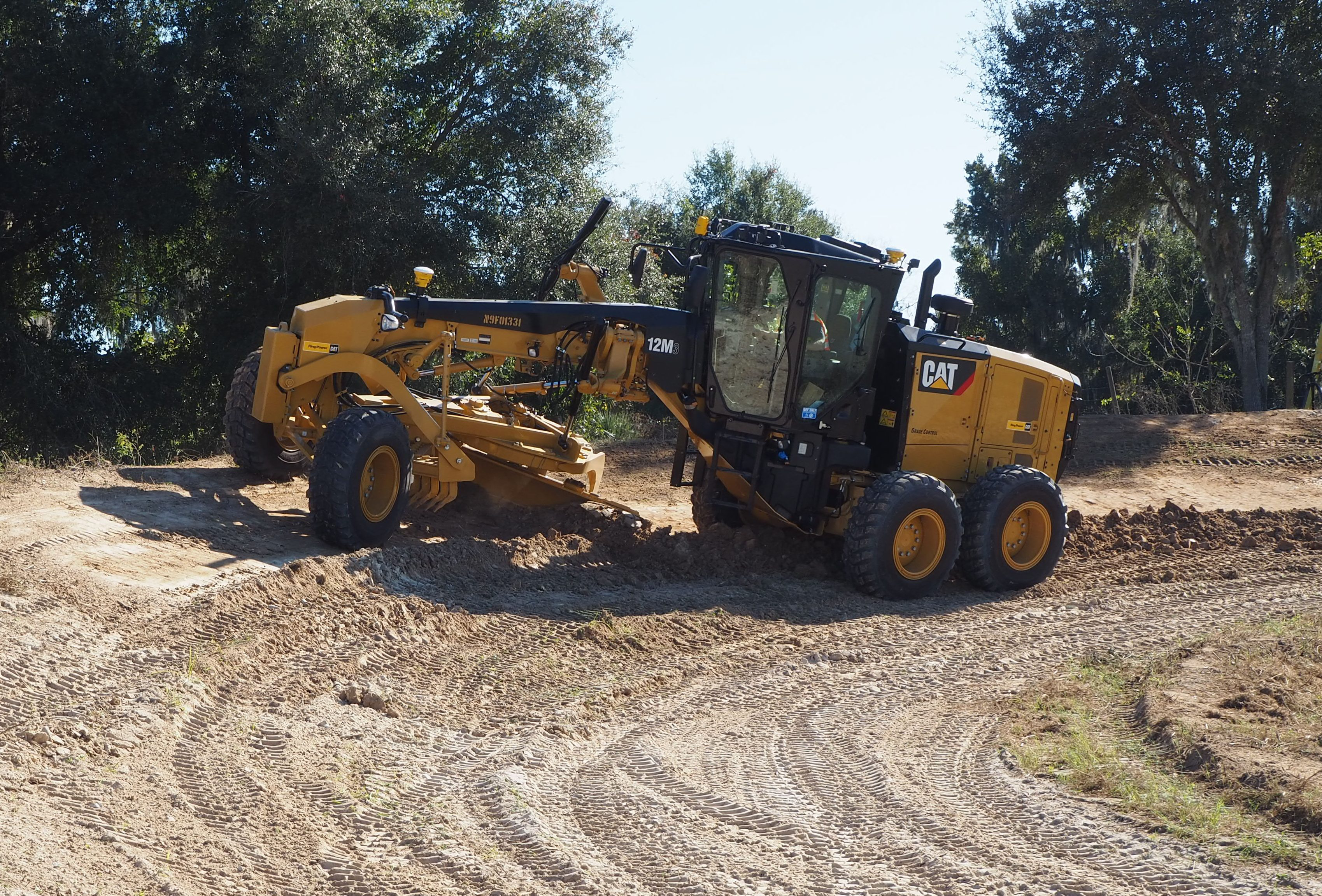 A motor grader working on a slope with the Trimble mastless grade control