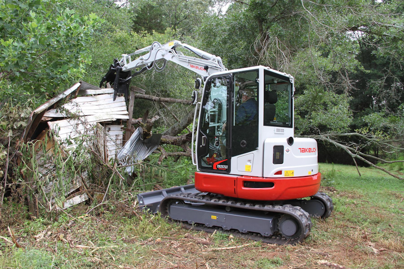 Takeuchi TB257FR compact excavator during demolition on small shed