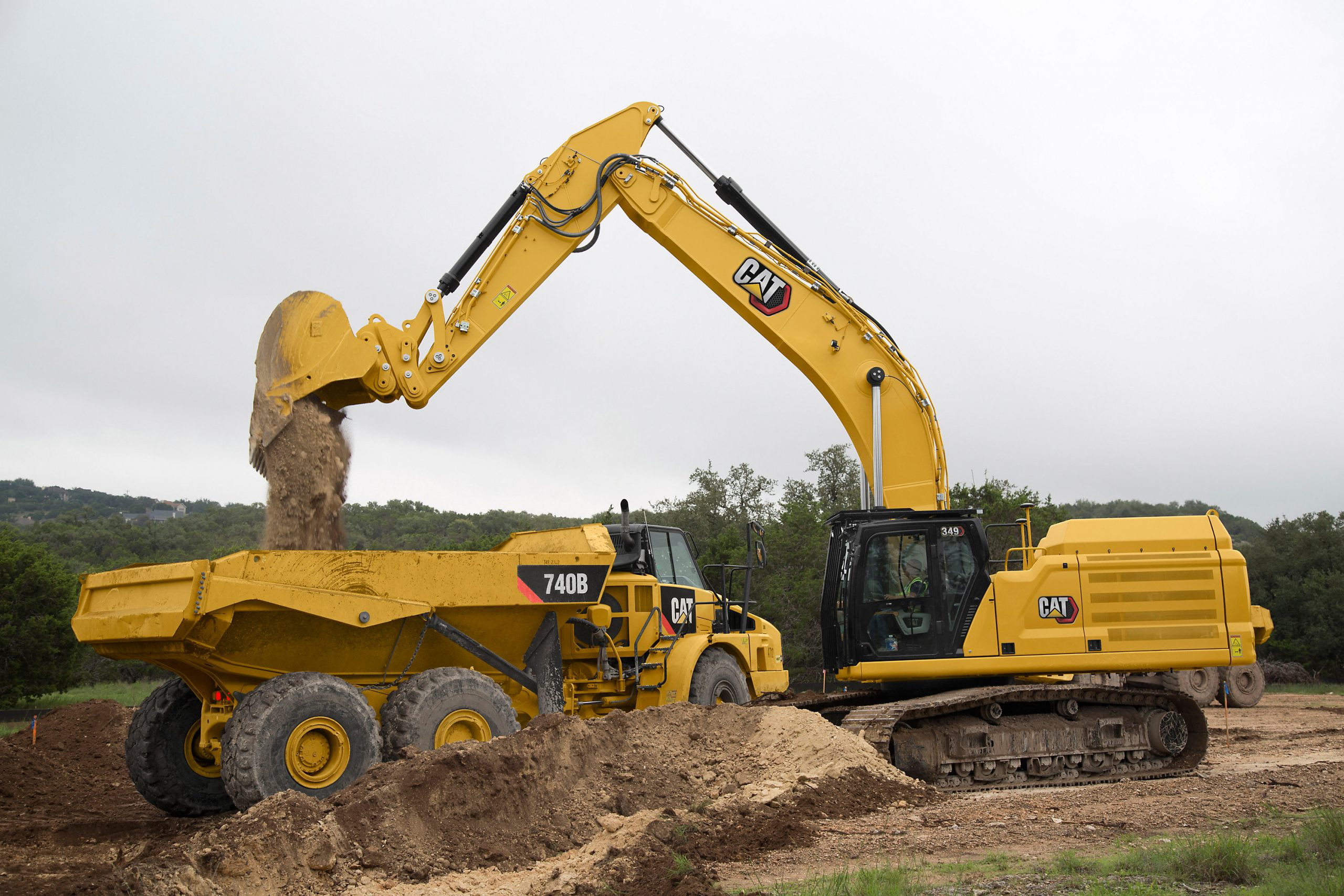 Cat excavator loads a Cat 740B with dirt