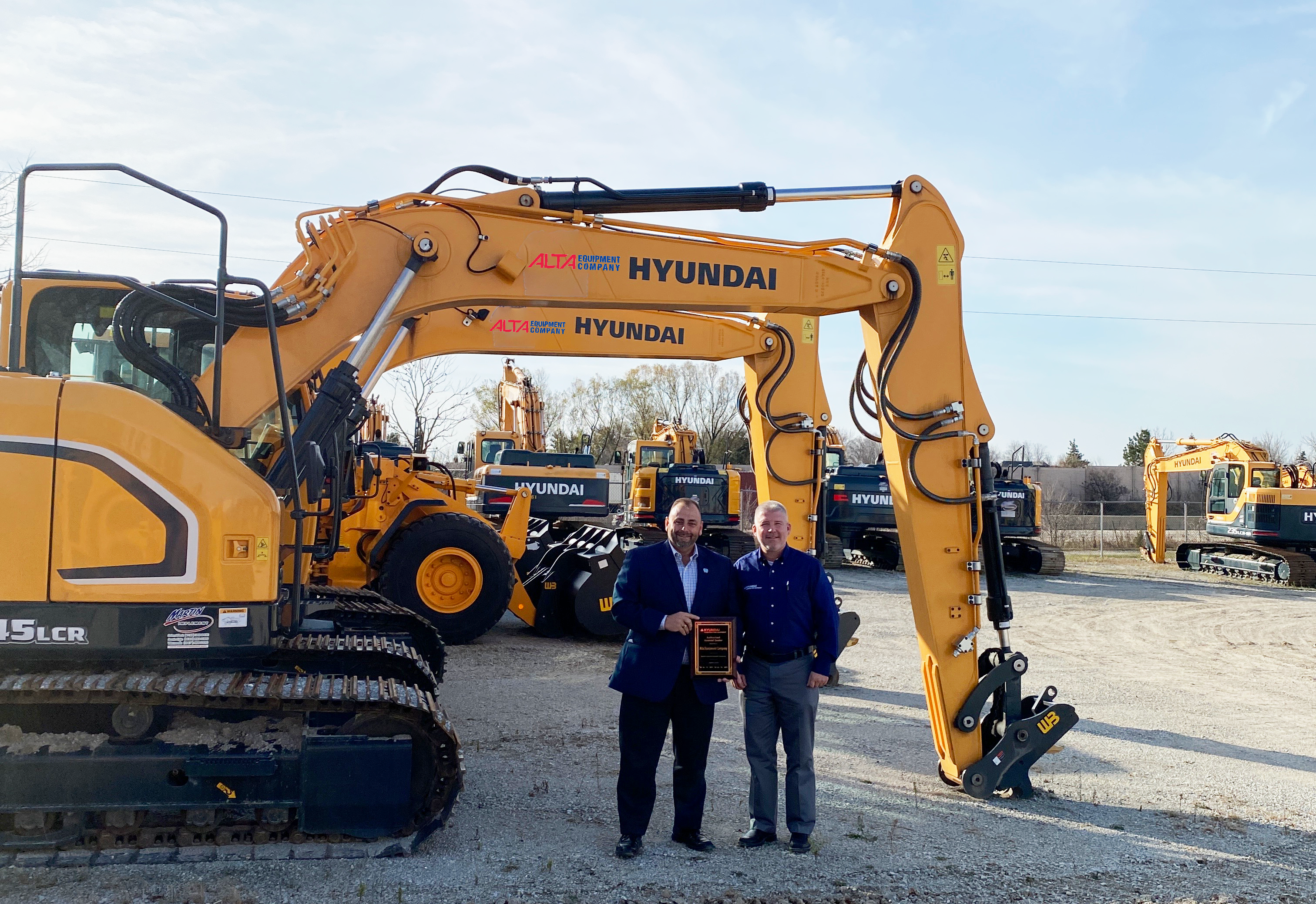 Mike Dahlen and Ed Harseim standing in front of Hyundai construction equipment